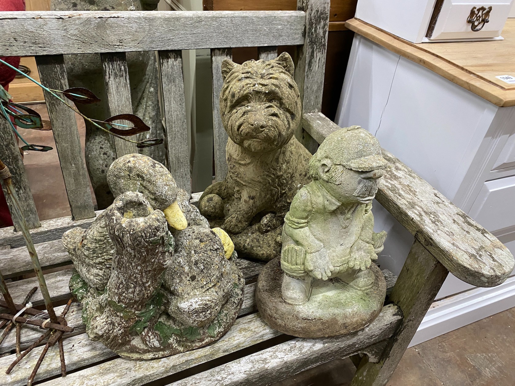 A group of four reconstituted stone garden ornaments and a painted metal peacock